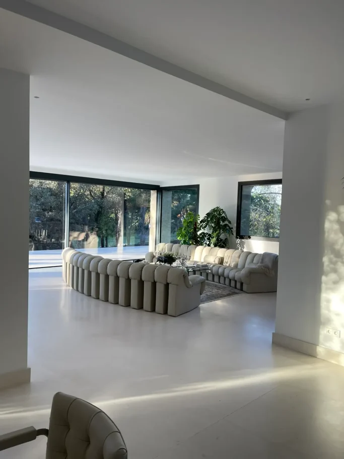 Amplio salón moderno ebanistería a medida e iluminación integrada en chalet reformado en Madrid.
