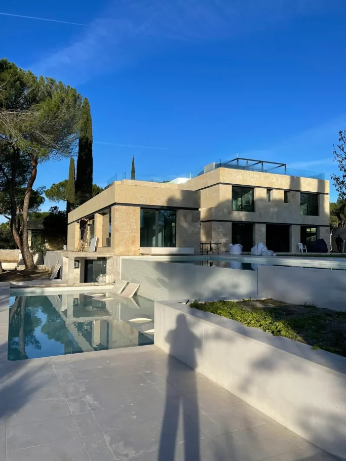 Diseño de jardín exterior con piscina moderna en la reforma integral de una residencia unifamiliar.
